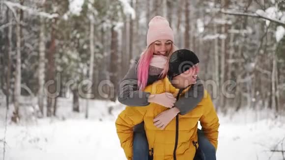 幸福的情侣漫步在白雪皑皑的冬林中一起度过圣诞假期户外季节性活动视频的预览图