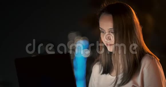 女开发商晚上坐在公园里看着笔记本电脑屏幕写代码视频的预览图