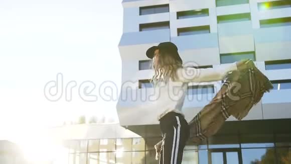 可爱的年轻女人玩围巾在建筑背景上旋转视频的预览图