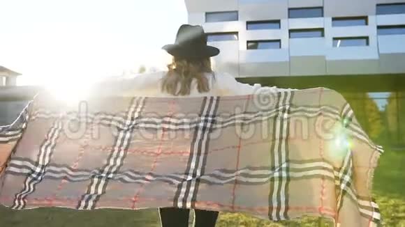 在现代建筑背景下快乐时尚的女孩在日出时带着围巾跑步视频的预览图