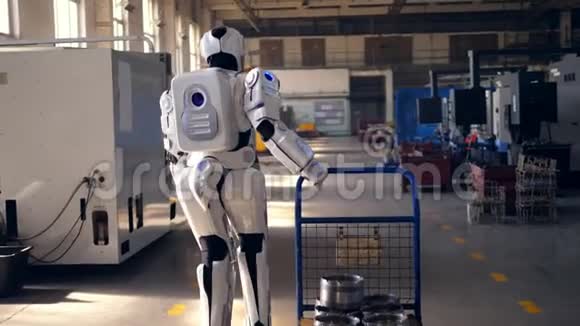 工作机器人拉着一辆金属手推车在一个设施里行走视频的预览图