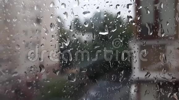 水滴在背景模糊的窗户上专注于雨滴街景视频的预览图