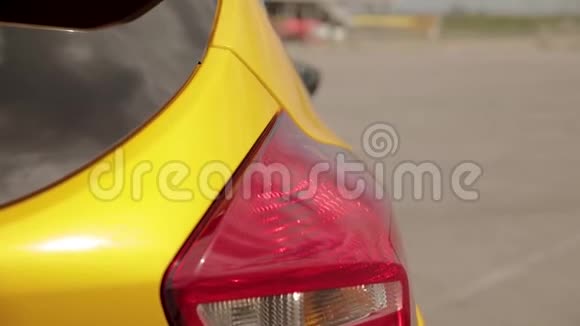 后方汽车灯和后视镜上的运动黄橙色汽车在停车场低调轮胎赛车视频的预览图
