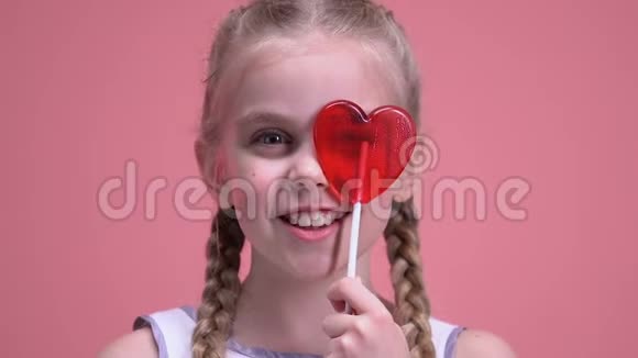 可爱的女孩玩得开心用心形棒棒糖闭眼情人节视频的预览图