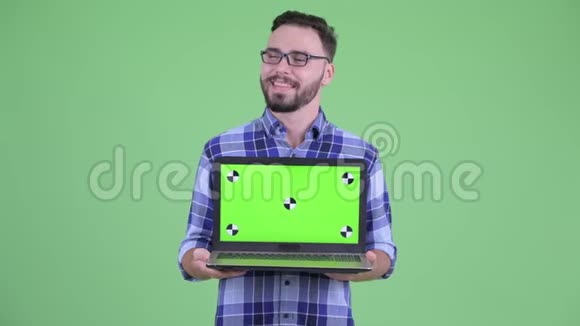 快乐的年轻有胡子的时髦男人一边看着笔记本电脑一边思考视频的预览图