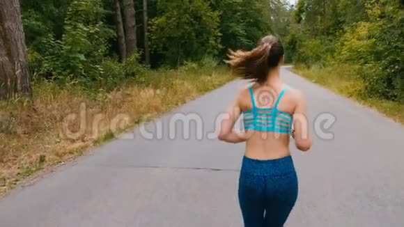 夏季公园年轻女子跑步训练的背面健身女孩在户外慢跑晨跑概念视频的预览图