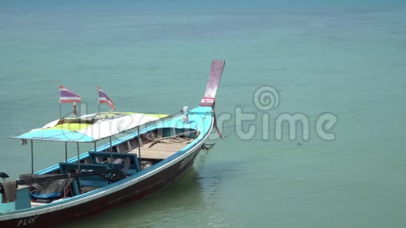 泰国长尾船在泰国普吉岛海岸外的热带海滩上经过海等待游客视频的预览图