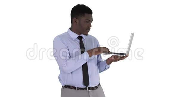 与镜头交谈年轻的非洲男子手拿笔记本电脑在白色背景视频的预览图