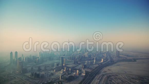 早上日出时在迪拜大城市的未来塔楼上空进行宏伟的空中无人机飞行视频的预览图