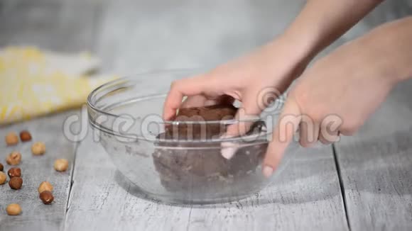 女性手揉巧克力棕色面团做饼干烹饪的概念视频的预览图