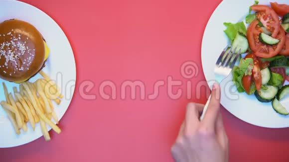 餐厅顾客从粉色背景的白色盘子里取食物午餐视频的预览图