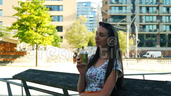一个年轻的女孩正在城里等人喝着咖啡去视频的预览图