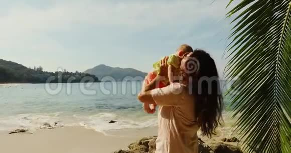 一位在沙滩上玩婴儿游戏的老妇人视频的预览图