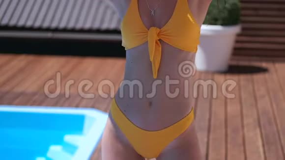 美丽的女孩穿着五颜六色的泳装美丽的身材玩着游泳池旁的充气玩具视频的预览图
