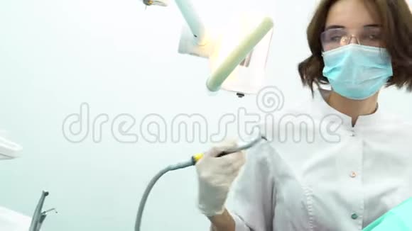 年轻女子坐在牙科椅上做牙医检查媒体美丽女牙医的侧景视频的预览图