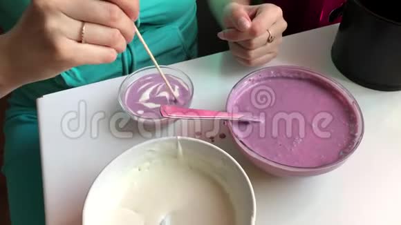 一个女人正在用棍子混合她的明胶甜点多种颜色的层次视频的预览图