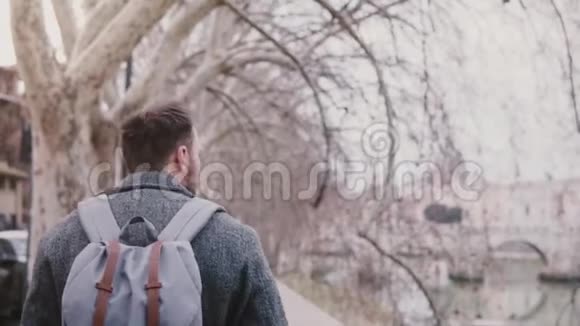 镜头跟随白人游客带着背包在秋天的罗马沿着泰伯河散步视频的预览图