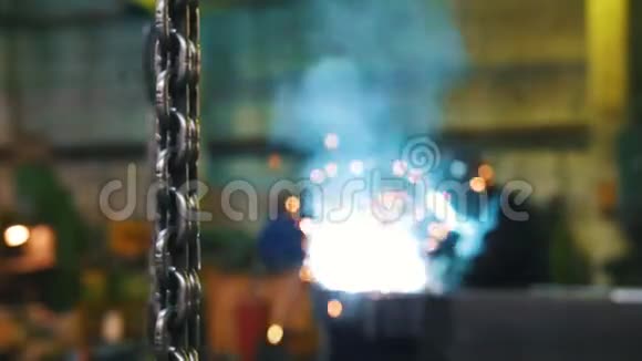 建筑工厂挂在前景上的金属链一个男人在后台焊接视频的预览图
