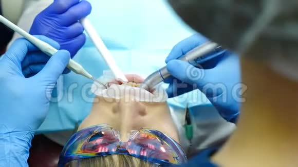 牙科诊所的概念牙科医生用扩张器治疗女性患者的特写镜头现代牙科视频的预览图