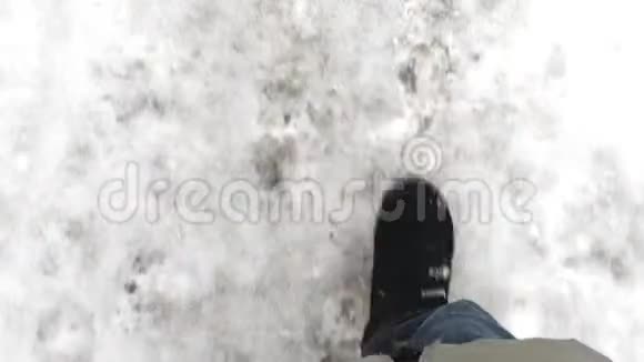 穿着黑色雪靴的女人走在白雪皑皑的冬天的路旁俯视风景视频的预览图