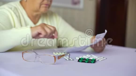 老年妇女在家戴眼镜阅读处方药说明书视频的预览图
