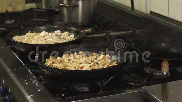 餐厅厨房的煤气炉上放着煎锅或煎锅和肉片视频的预览图