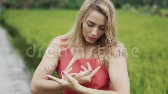 一个金发碧眼的金发美女在外面跳舞轻轻地移动身体手手和手指感觉视频的预览图