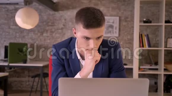 年轻集中的商人正在办公室里看笔记本电脑看到好的结果保持手握拳是的手势是的生意视频的预览图