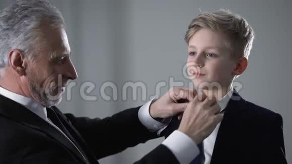 成熟的父亲调整小儿子领带以孩子为荣未来的事业接班人视频的预览图
