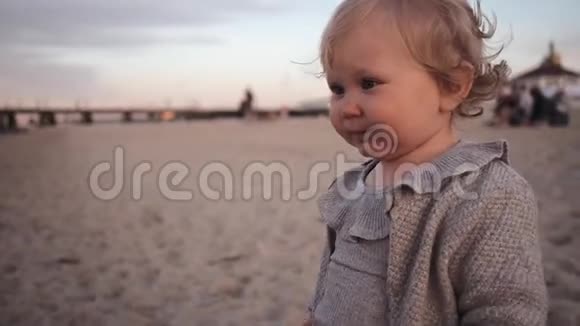 小卷曲的女孩在海滩上吃了无味的沙子吐了又吐视频的预览图