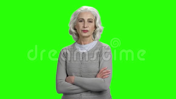 高级妇女交叉双臂在绿色屏幕上视频的预览图
