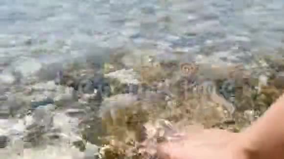 特写女性手触海波在海边休息的女孩海洋卵石旅游旅游和娱乐视频的预览图