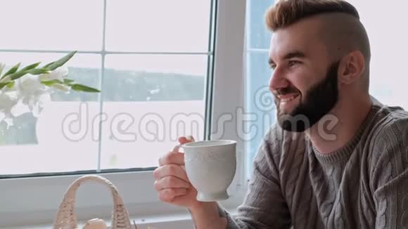 一对年轻漂亮的夫妇穿着温暖的毛衣坐在白色的桌子旁背景是视频的预览图