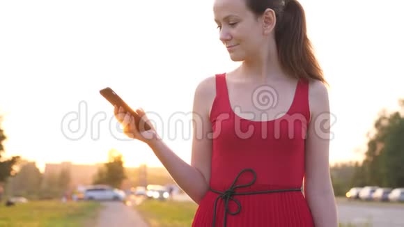 带智能手机的红衣快乐女人城市生活理念视频的预览图