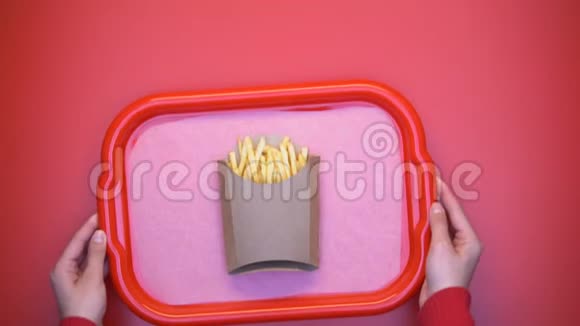 女人把塑料托盘和炸薯条放在桌子上脆脆的土豆小吃视频的预览图
