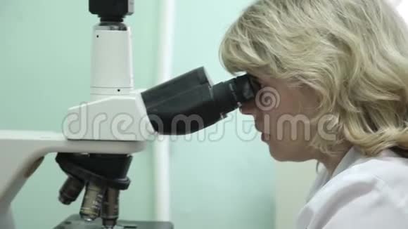 特写镜头一名女实验室技术人员使用显微镜视频的预览图