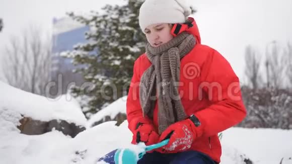 少女从雪球制造者手里拿雪球视频的预览图