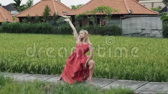 一个体格健壮的女孩穿着一件红色的长裙在现代舞蹈中她想出了一个舞蹈动作视频的预览图