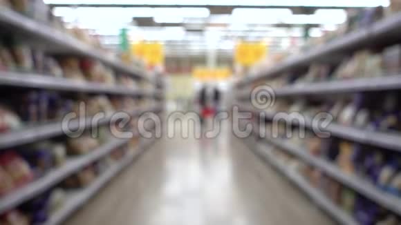 店背景模糊人带购物车人们在超市购物离焦模糊的背景视频的预览图