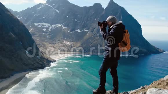 专业摄影师男性带单反背包拍摄山谷风景视频的预览图