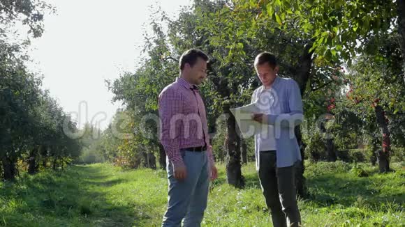 两个农民在苹果园达成协议视频的预览图