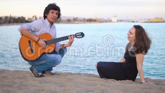 美丽的音乐家夫妇坐在海边的码头上视频的预览图