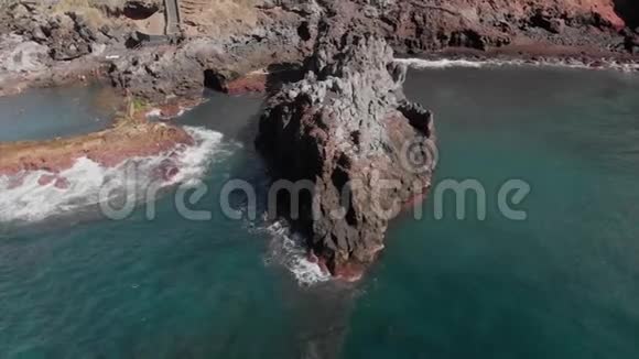 空中射击阳光明媚的一天在海洋和岩石火山海岸上空盘旋蓝色的海岸视频的预览图