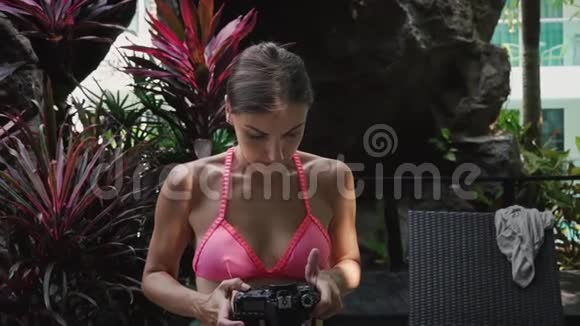 女孩摄影师用相机设置相机拍摄看照片视频的预览图