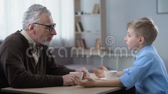 快乐的小男孩和爷爷分享消息信任的家庭关系视频的预览图