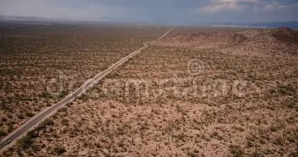 无人机飞离开美丽的沙漠道路上惊人的巨大仙人掌领域与汽车驾驶在亚利桑那州国家公园视频的预览图