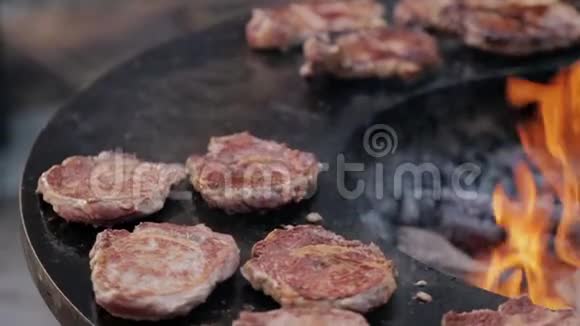 街市上铸铁烤架上的烤猪肉牛排视频的预览图
