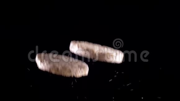 两个米饭和玉米面包在黑色背景上飞起来慢动作视频的预览图