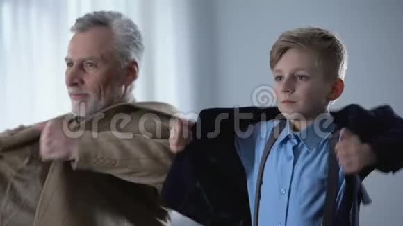 可爱的祖父和孙子穿上夹克准备一起散步视频的预览图