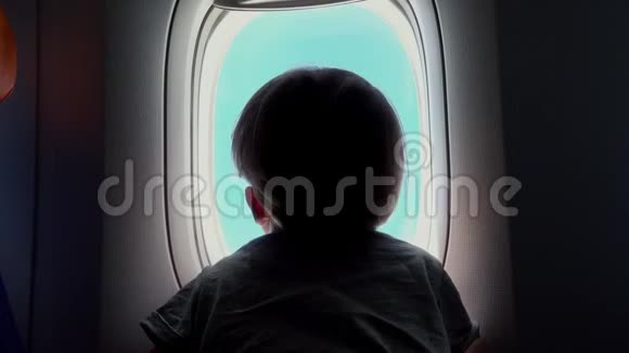 坐在座位上的男孩看着飞机窗外视频的预览图